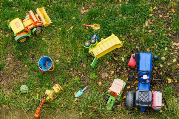 Children toys outdoors on green grass.